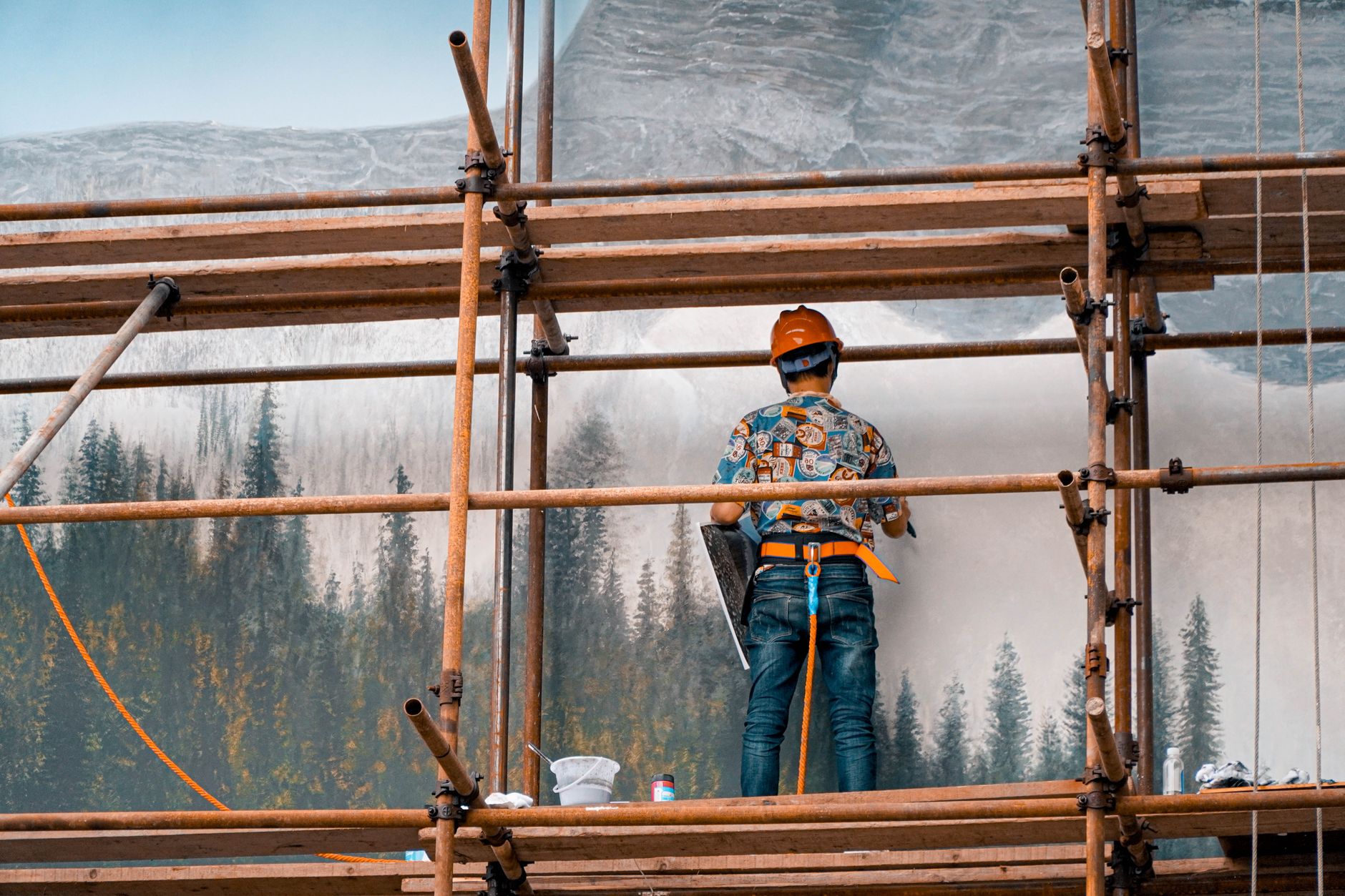 A worker on scaffolding wearing fall-protection equipment